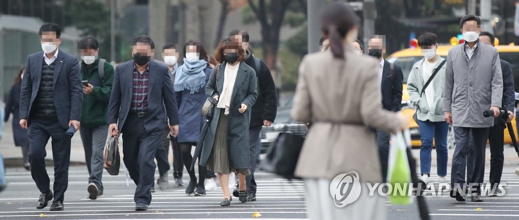 １１月１８日朝、ソウル市内の通勤風景。誰もがマスクを着用している＝（聯合ニュース）