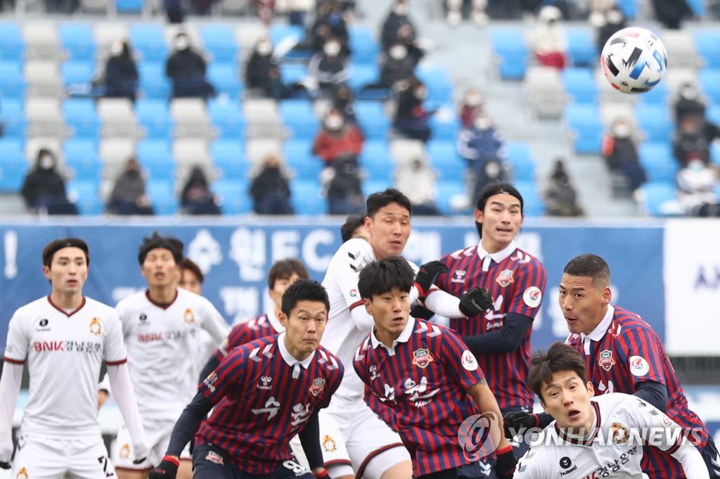 Players for Suwon FC (in red) and Gyeongnam FC vie for the ball during their K League 2 promotion playoff match at Suwon Sports Complex in Suwon, 45 kilometers south of Seoul, on Nov. 29, 2020. (Yonhap)