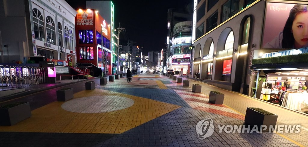 There is little traffic on a street in front of Hongik University, usually one of the busiest streets in Seoul, on the night of Dec. 9, 2020, when new virus cases recorded the second-highest mark of 686 since January. (Yonhap)