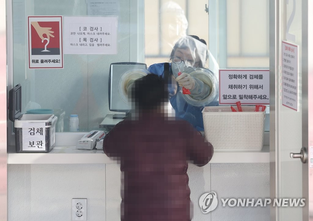 A citizen undergoes a coronavirus test in western Seoul on Dec. 12, 2020, as South Korea's daily number of new virus cases hit a record high of 950 nearly 11 months after the country reported its first virus case in January. (Yonhap)