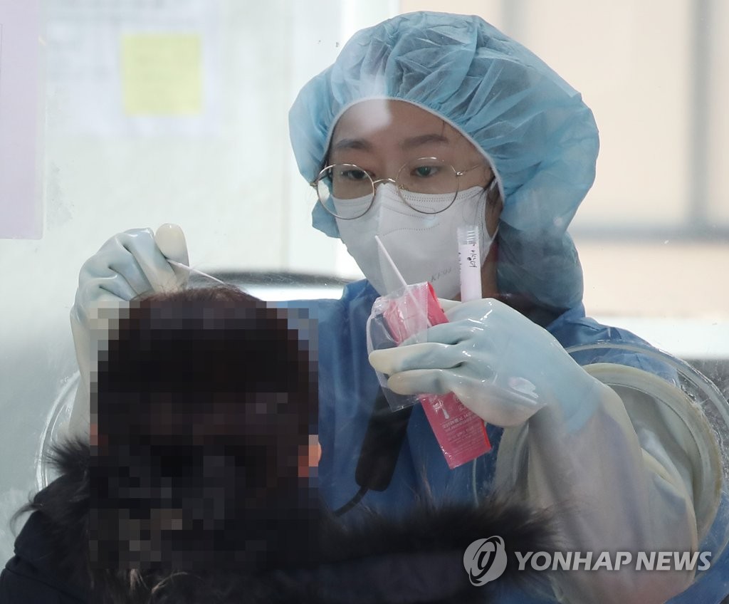 A medical worker carries out a COVID-19 test on a visitor at a makeshift clinic in western Seoul on Dec. 15, 2020. (Yonhap)
