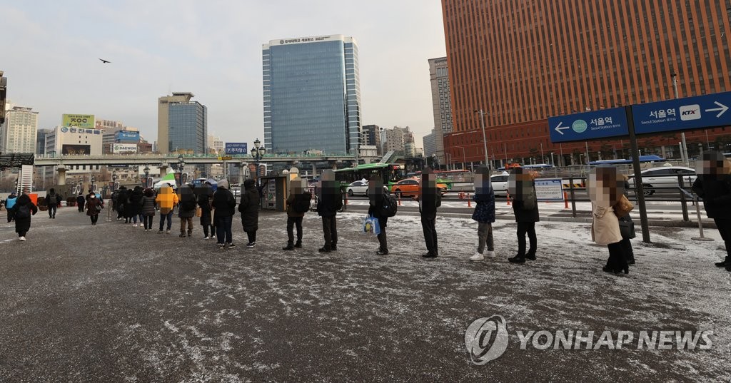People stand in line for COVID-19 testing at a temporary screening station in front of Seoul Station on Dec. 18, 2020. (Yonhap)