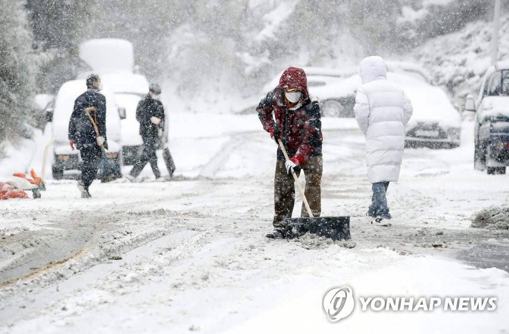 This photo taken on Jan. 7, 2020, shows public officials shoveling snow on a street in Gwangju, 330 kilometers southwest of Seoul, with a cold wave warning issued in many parts of the country. (Yonhap) 