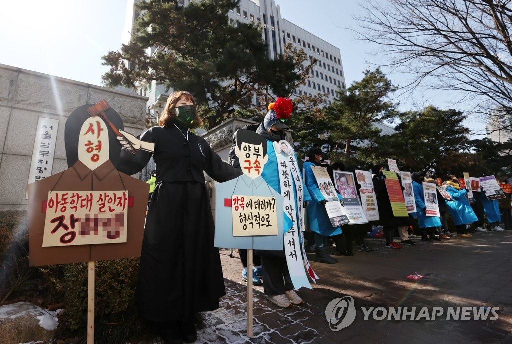 This Feb. 17, 2021, file photo shows people calling for stern punishment against two parents, who allegedly abused their 16-month-old adopted daughter to death in October, in front of the Seoul Southern District Court. (Yonhap)