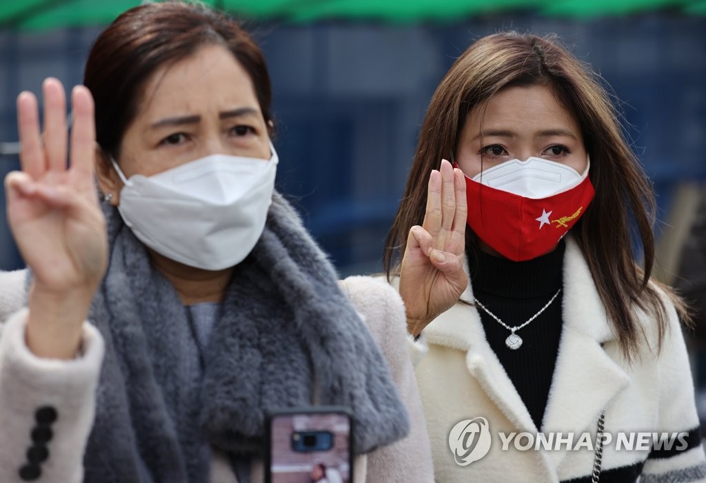Myanmarese women hold up three fingers in a gesture of resistance to the coup in their home country during a news conference in front of the Myanmar Embassy in Seoul on March 2, 2021. (Yonhap)