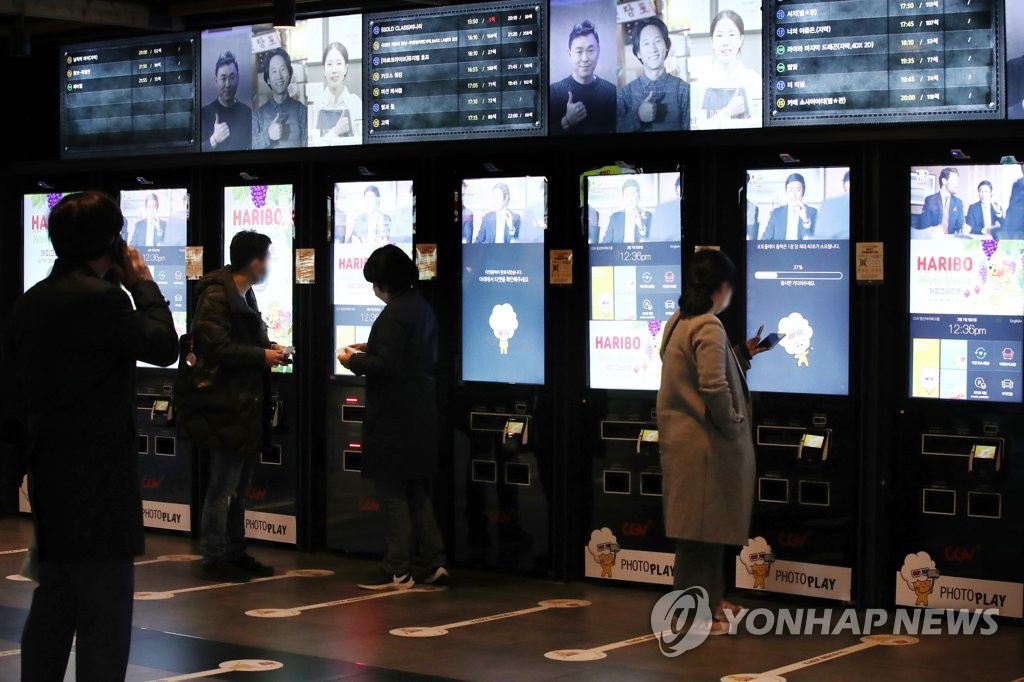 In this file photo taken March 7, 2021, people buy tickets at a movie theater in Seoul. (Yonhap)