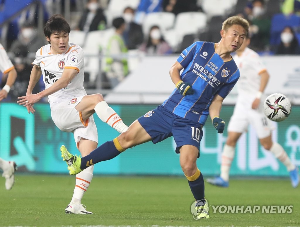 In this file photo from March 16, 2021, Kang Yoon-seong of Jeju United (L) takes a shot past Yoon Bitgaram of Ulsan Hyundai FC during a K League 1 match at Ulsan Munsu Football Stadium in Ulsan, 415 kilometers southeast of Seoul. (Yonhap)