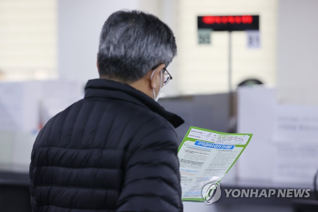 This March 24, 2021, file photo shows a man reading guidelines on applying for benefits at a state-run job center in western Seoul. (Yonhap)