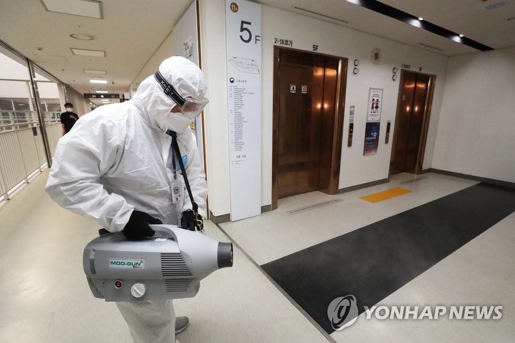 A quarantine worker disinfects the floor of the labor ministry in Sejong, central South Korea, on March 31, 2021, as a ministry employee has been infected with the new coronavirus. (Yonhap)