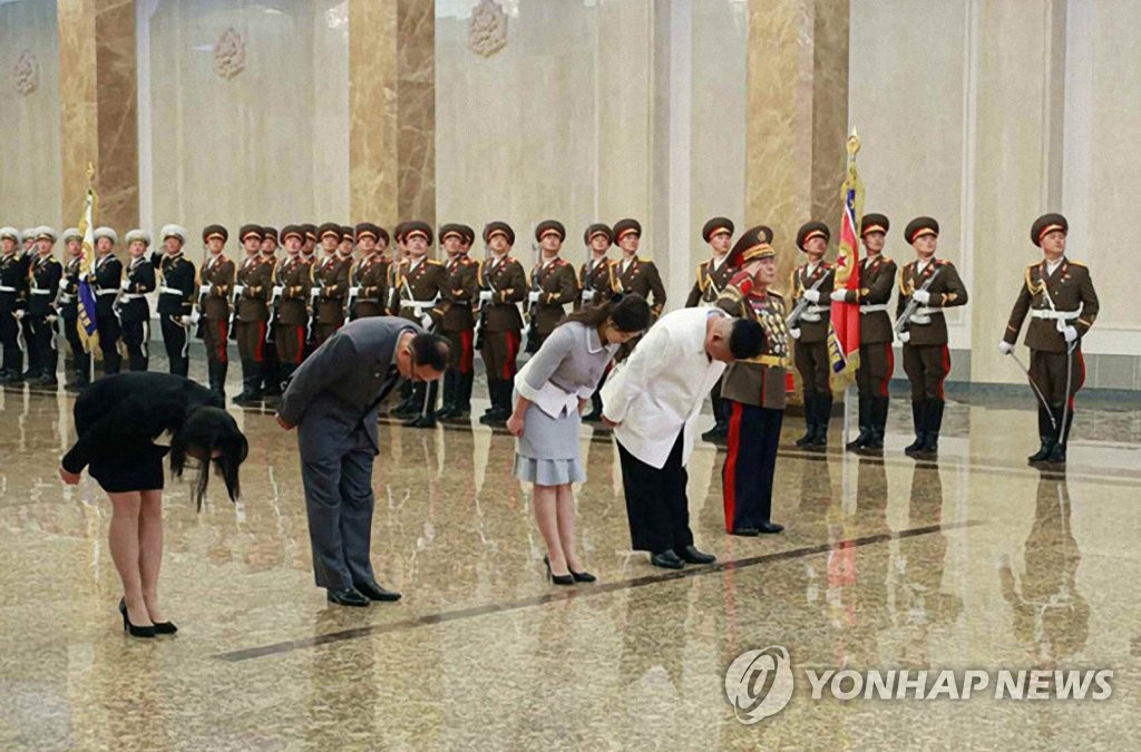 Le dirigeant nord-coréen Kim Jong-un (à dr.) à et son épouse Ri Sol-ju (2e à partir de la dr.) rendent hommage au fondateur de la Corée du Nord, Kim Il-sung, au Palais du Soleil de Kumsusan pour marquer son anniversaire, a rapporté le vendredi 16 avril 2021 le quotidien officiel nord-coréen Rodong Sinmun. (Revente et archivage interdits) A gauche, se trouve Kim Yo-jong, la sœur du dirigeant nord-coréen. 