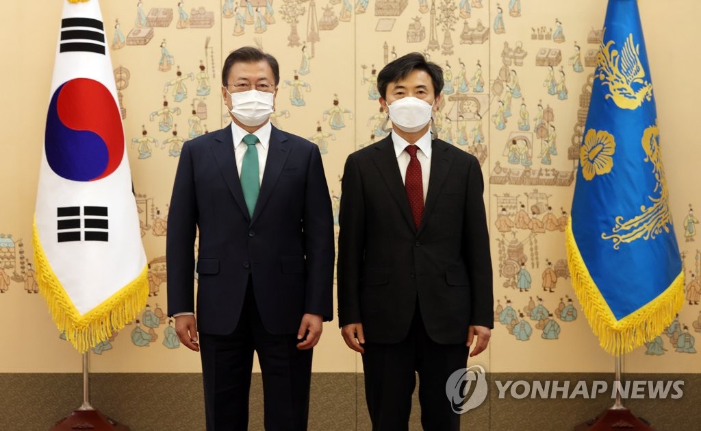 President Moon Jae-in (L) poses for a photo with Lee Hyun-joo at the presidential office Cheong Wa Dae in Seoul on April 23, 2021, after appointing him as the special prosecutor to helm a fact-finding probe on the 2014 Sewol ferry sinking. (Yonhap)