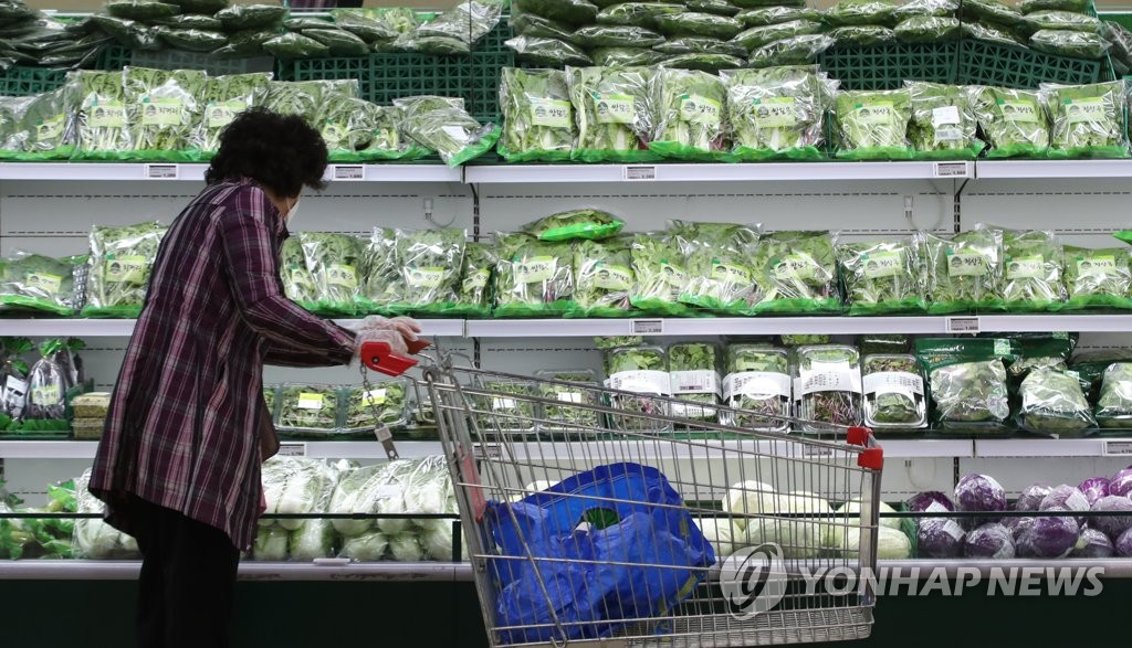 Une cliente choisit des légumes dans une grande surface à Séoul, le dimanche 9 mai 2021. 