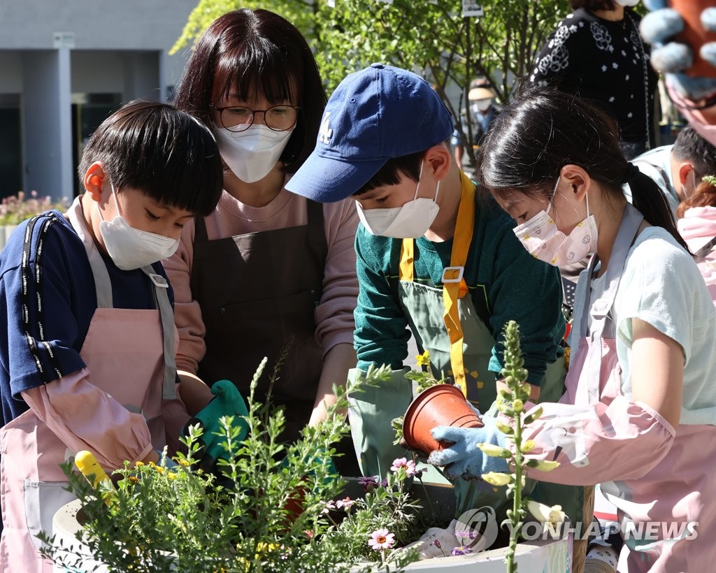 In this photo taken on May 9, 2021, a family participates in an offline gardening event held in Manri-dong, central Seoul, amid the COVID-19 pandemic as part of the Seoul International Garden Show scheduled from May 14-20. (Yonhap) 