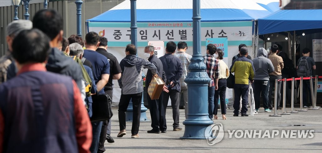 Des gens font la queue pour se faire tester dans un centre de dépistage pour le Covid-19, installé proviroirement devant la gare de Séoul, le 4 juin 2021.