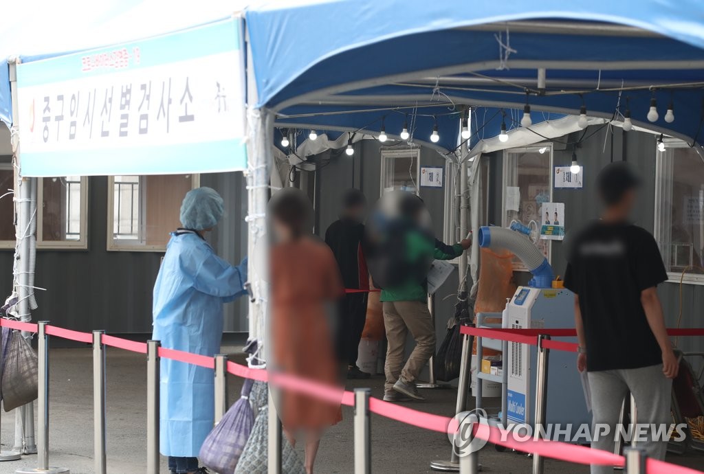 Des gens font la queue pour se faire tester dans un centre de dépistage pour le Covid-19, à la gare de Séoul, le 5 juin 2021. 