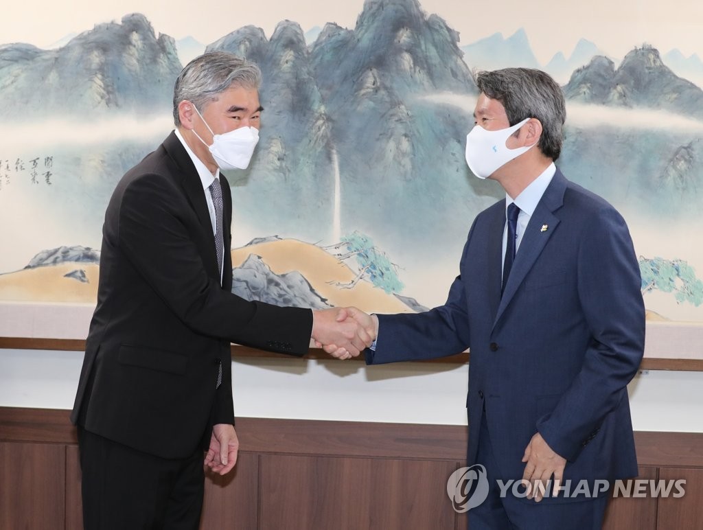 Le ministre de l'Unification Lee In-young (à dr.) serre la main du représentant spécial des Etats-Unis pour la Corée du Nord, Sung Kim, le mardi 22 juin 2021 lors d'une réunion dans son bureau à Séoul. 