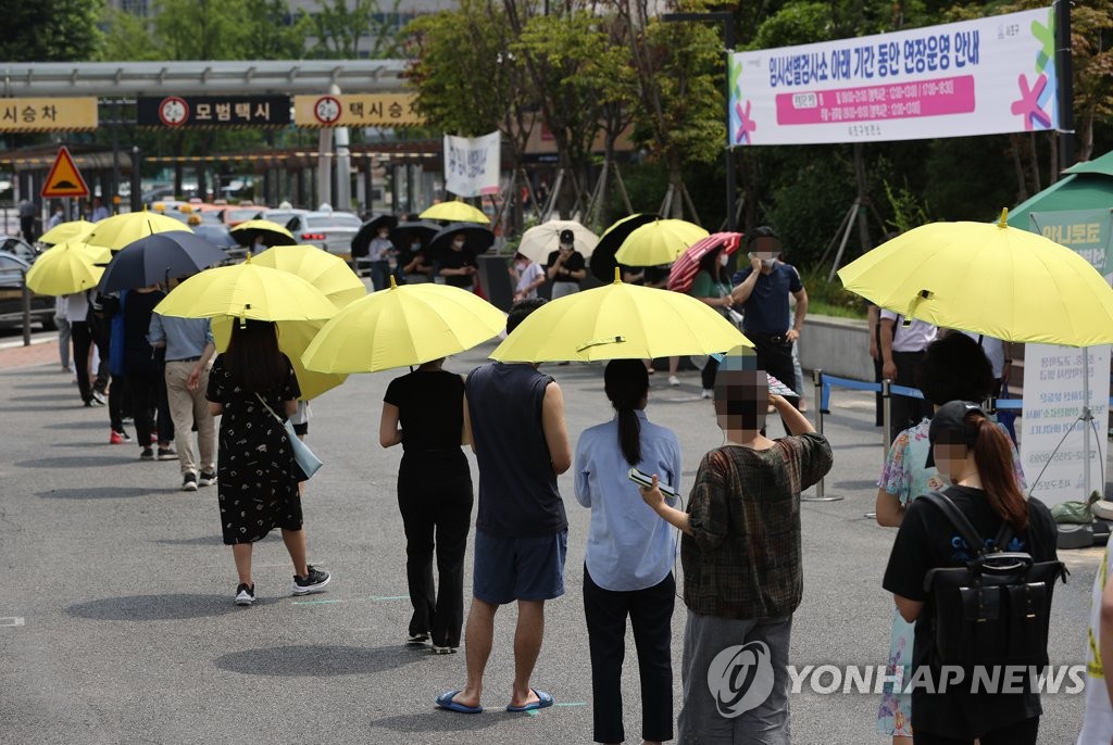 Citizens wait to receive COVID-19 tests at a makeshift clinic in southern Seoul on July 13, 2021. (Yonhap)