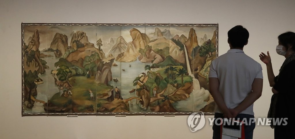 In this file photo, reporters look at "Paradise" by late Korean painter Paek Nam-soon during a press preview of a special exhibition of late Samsung Group Chairman Lee Kun-hee's art collection at the National Museum of Modern and Contemporary Art in Seoul on July 20, 2021. (Yonhap)