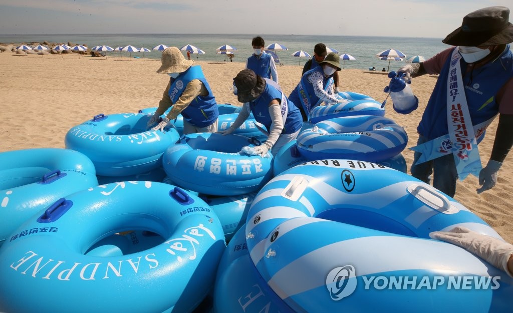 Volunteers sterilize swimming tubes at a beach in the eastern coastal city of Gangneung on July 22, 2021. (Yonhap)
