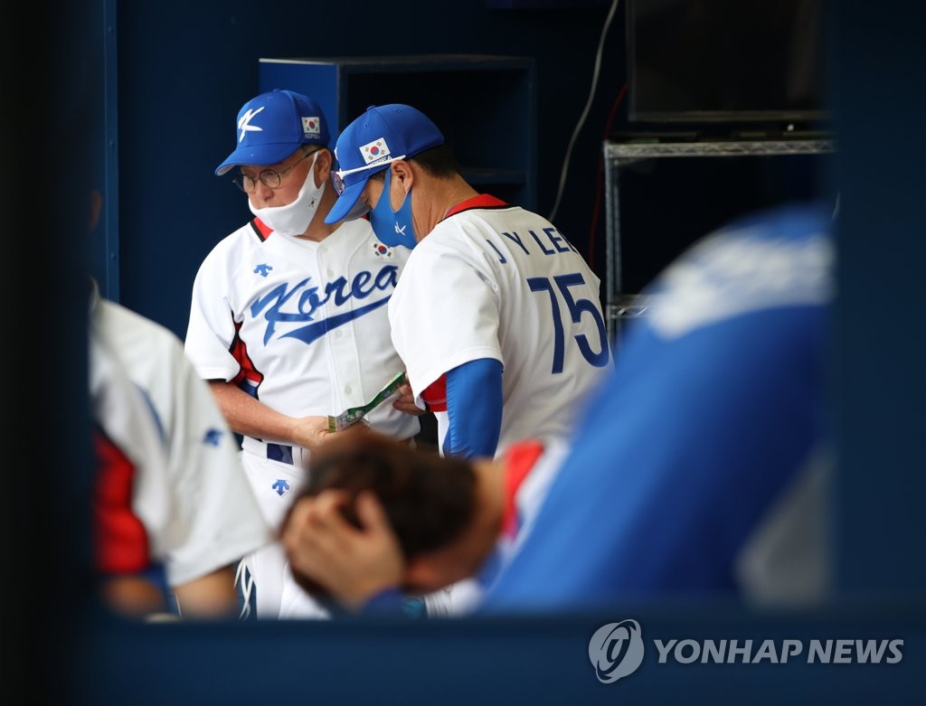 South Korean manager Kim Kyung-moon (L) prepares to leave the dugout after the team's 10-6 loss to the Dominican Republic in the bronze medal game at the Tokyo Olympic baseball tournament at Yokohama Stadium in Yokohama, Japan, on Aug. 7, 2021. (Yonhap)