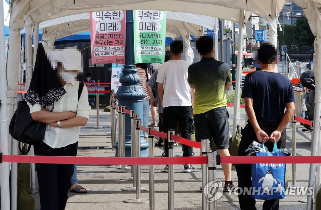 ソウル駅前の広場にある臨時検査所で市民が検査の順番を待っている＝１６日、ソウル（聯合ニュース）