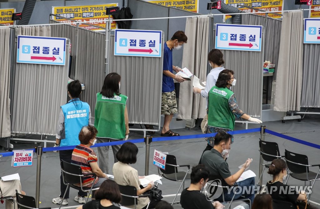 People wait to get vaccinated at a vaccine site in Seoul on Aug. 27, 2021. (Yonhap) 