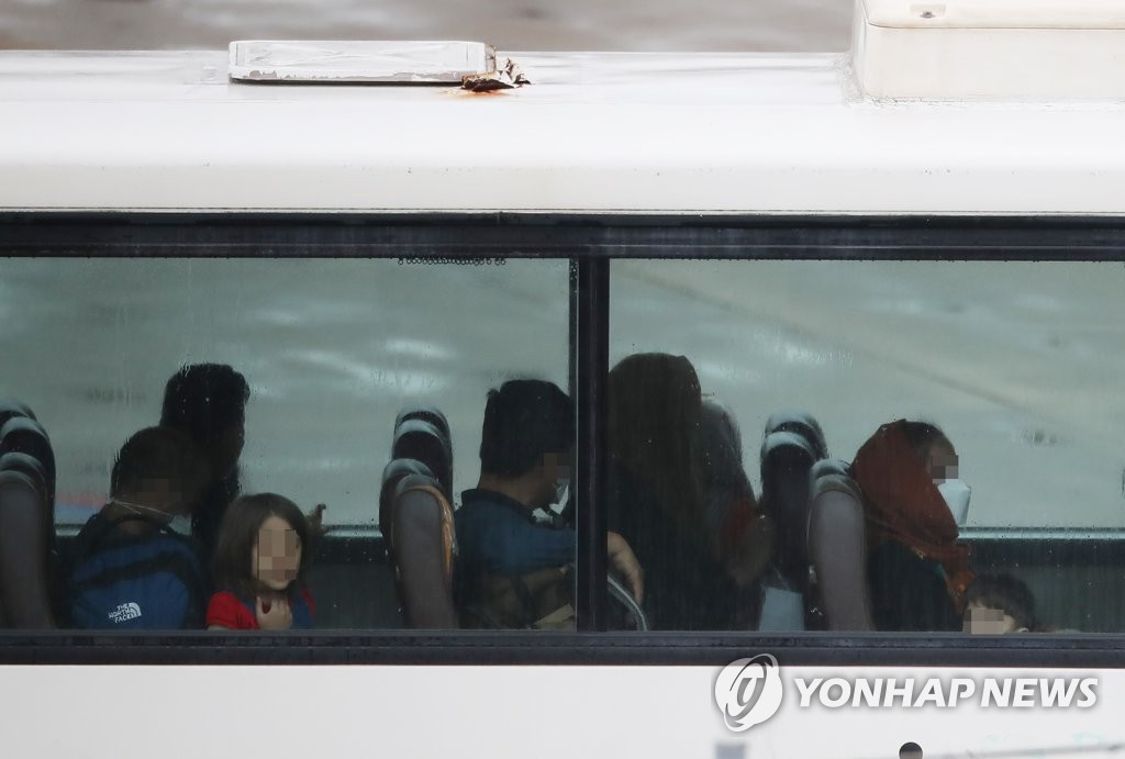 仁川国際空港に到着した韓国機関の現地スタッフとその家族１３人が、ＰＣＲ検査を受けるためバスで移動している＝２７日、仁川（聯合ニュース）