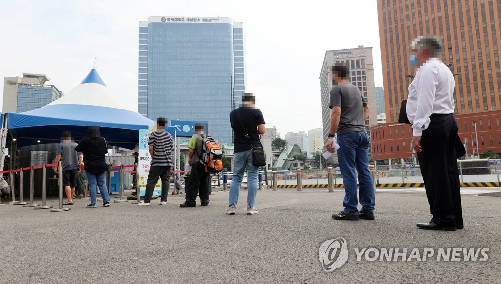 Citizens wait in line to receive COVID-19 tests at a makeshift clinic in central Seoul on Aug. 30, 2021. (Yonhap)
