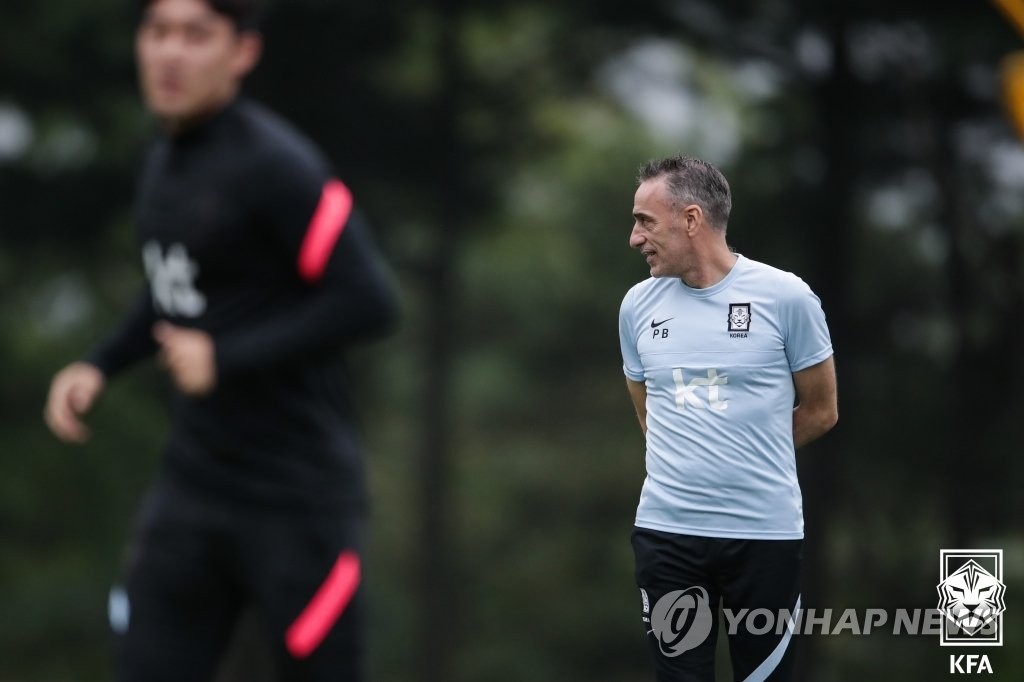 Paulo Bento (R), head coach of the South Korean men's national football team, watches his players during a training session at the National Football Center in Paju, Gyeonggi Province, on Oct. 5, 2021, in preparation for 2022 FIFA World Cup qualifying matches, in this photo provided by the Korea Football Association. (PHOTO NOT FOR SALE) (Yonhap)