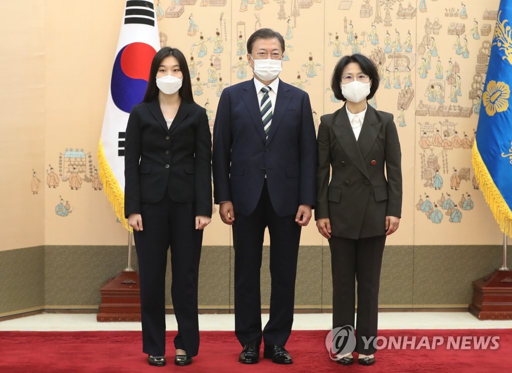 President Moon Jae-in (C) poses with Oh Kyung-mi (R) after conferring a letter of appointment as a Supreme Court justice on her at the presidential office in Seoul on Oct. 6, 2021. On the left is Oh's daughter. (Yonhap)