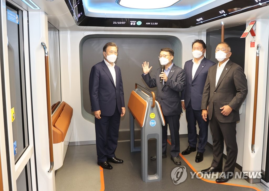 President Moon Jae-in (L) has a trial ride on a hydrogen-fueled tram made by Hyundai Rotem Co. after attending a groundbreaking ceremony for a next-generation hydrogen fuel cell complex in Incheon, 40 kilometers west of Seoul, on Oct. 7, 2021. SK Group Chairman Chey Tae-won (2nd from R) and Hyundai Automotive Group Chairman Chung Eui-sun (R) were on hand. (Yonhap)