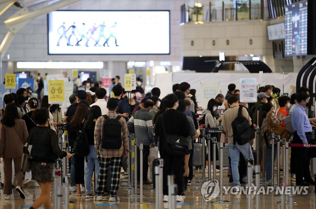 La foto, tomada, el 8 de octubre de 2021, muestra a viajeros esperando en fila para su vuelos en el Aeropuerto Internacional de Gimpo, en el oeste de Seúl.