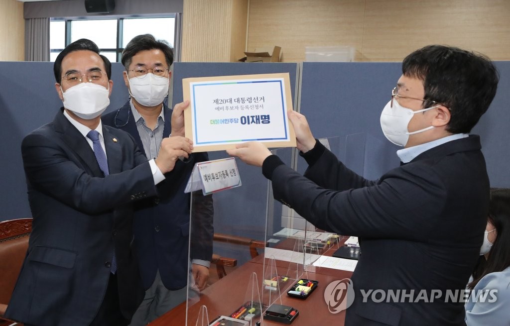 Democratic Party Reps. Park Hong-keun (L) and Park Chan-dae (C) submit papers to register DP presidential nominee Lee Jae-myung as a preliminary presidential candidate at the National Election Commission's office in Gwacheon, 18 kilometers south of Seoul, on Oct. 26, 2021. (Yonhap)