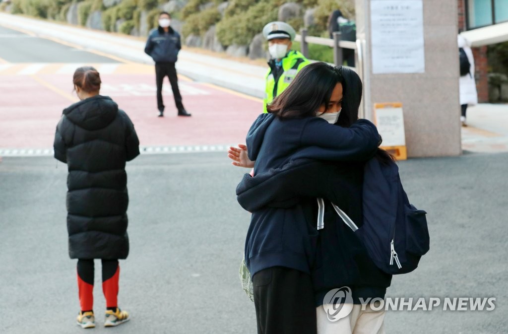 '그동안 고생 많았어'  (부산=연합뉴스) 손형주 기자 = 2022학년도 대학수학능력시험(수능)일인 18일 부산 덕문여자고등학교에 마련된 고사장에 한 수험생 학부모가 입실하는 수험생 자녀를 안아주고 있다. 이 학부모는 '결과에 상관없이 그동안 과정이 중요하다. 끝나고 꼭 맛있는 고기를 먹자'고 딸에게 전했다. 2021.11.18 handbrother@yna.co.kr