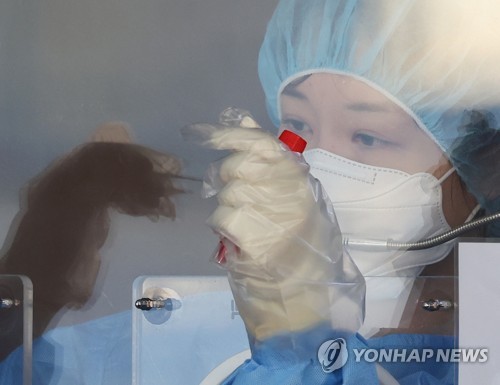 Una trabajadora médica recolecta muestras, el 26 de noviembre de 2021, en una clínica provisional para exámenes de coronavirus frente a la Estación de Seúl, en la capital surcoreana. 