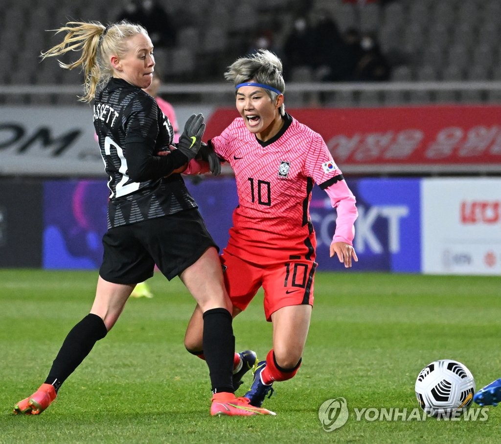 Ji So-yun of South Korea (R) is taken down by Betsy Hassett of New Zealand during the teams' friendly football match at Goyang Stadium in Goyang, Gyeonggi Province, on Nov. 30, 2021. (Yonhap)