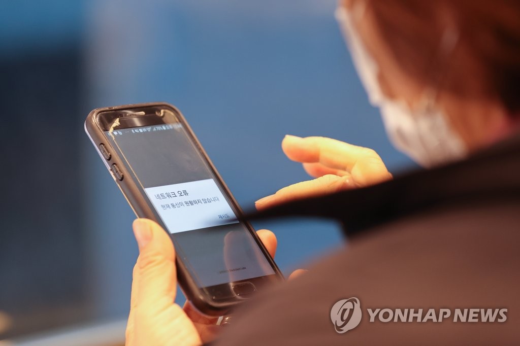 ソウル市内の飲食店で来店客のスマホのアプリ画面にエラーが表示されている＝１３日、ソウル（聯合ニュース）