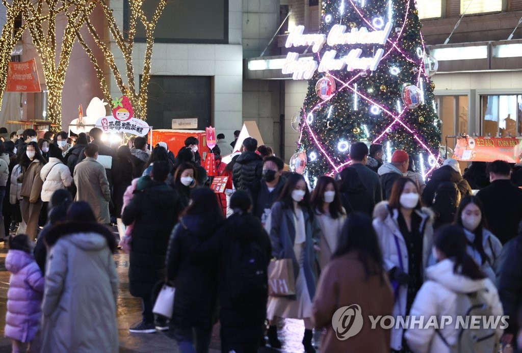 This photo, taken Dec. 19, 2021, shows citizens walking around the shopping district of Myeongdong in Seoul. (Yonhap)