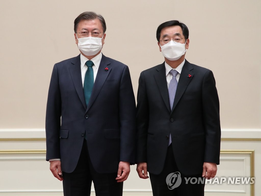 El presidente surcoreano, Moon Jae-in (izda.), posa para una foto después de entregar las cartas credenciales al nuevo embajador surcoreano ante Guatemala, Jang Ha-yeon, el 21 de diciembre de 2021, en la oficina presidencial, Cheong Wa Dae, en Seúl. 