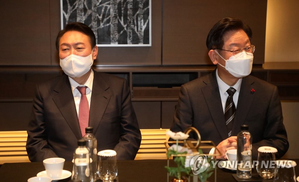 Le candidat présidentiel du Parti démocrate (PD) au pouvoir, Lee Jae-myung (à droite), et son principal rival du Parti du pouvoir du peuple (PPP), Yoon Suk-yeol, lors d'un événement sur la croissance nationale équlibrée dans un hôtel à Séoul, le 28 décembre 2021. (Pool photo)