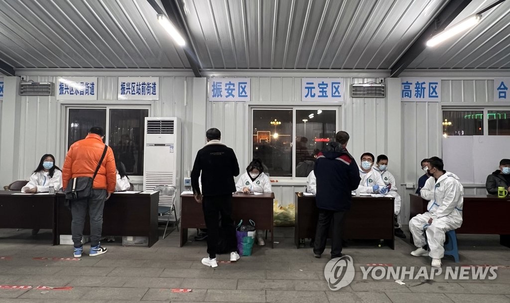 People stand in line to receive polymerase chain reaction (PCR) test certificates at Dandong Station in China's northeastern border city of Dandong, Liaoning Province, on Jan. 9, 2022, as all passengers using train stations and airports in the city are required to take the test at the scene under toughened social distancing rules. (Yonhap)