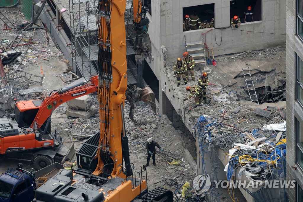 Les membres de l'équipe de secouristes 119 travaillent sur le site de l'effondrement d'un immeuble en construction dans le quartier de Hwajeong à Gwangju, dans le sud-ouest du pays, le dimanche 16 janvier 2022. Cinq personnes sont portées disparues lors de l'effondrement du mardi 11 janvier. 