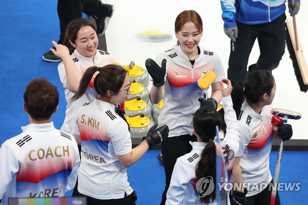 Members of the South Korean women's curling team at Beijing 2022 high five each other after practice at the National Aquatics Centre in Beijing on Feb. 9, 2022. (Yonhap)