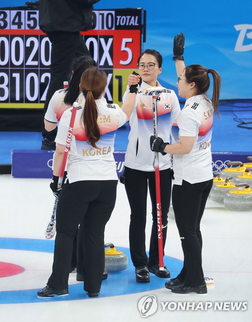 Les membres de l'équipe féminine de curling expriment leur joie après avoir remporté leur match contre le Japon le lundi 14 février 2022 au Centre aquatique national à Pékin. 