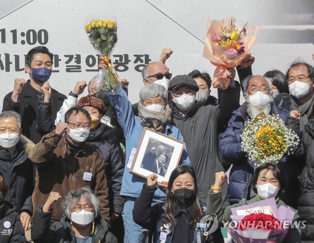 Kim Jin-suk (C) and her colleagues raise their hands during a ceremony for her honorary reinstatement and retirement at HJ Shipbuilding & Construction Co. in the southeastern port city of Busan on Feb. 25, 2022. (Yonhap)