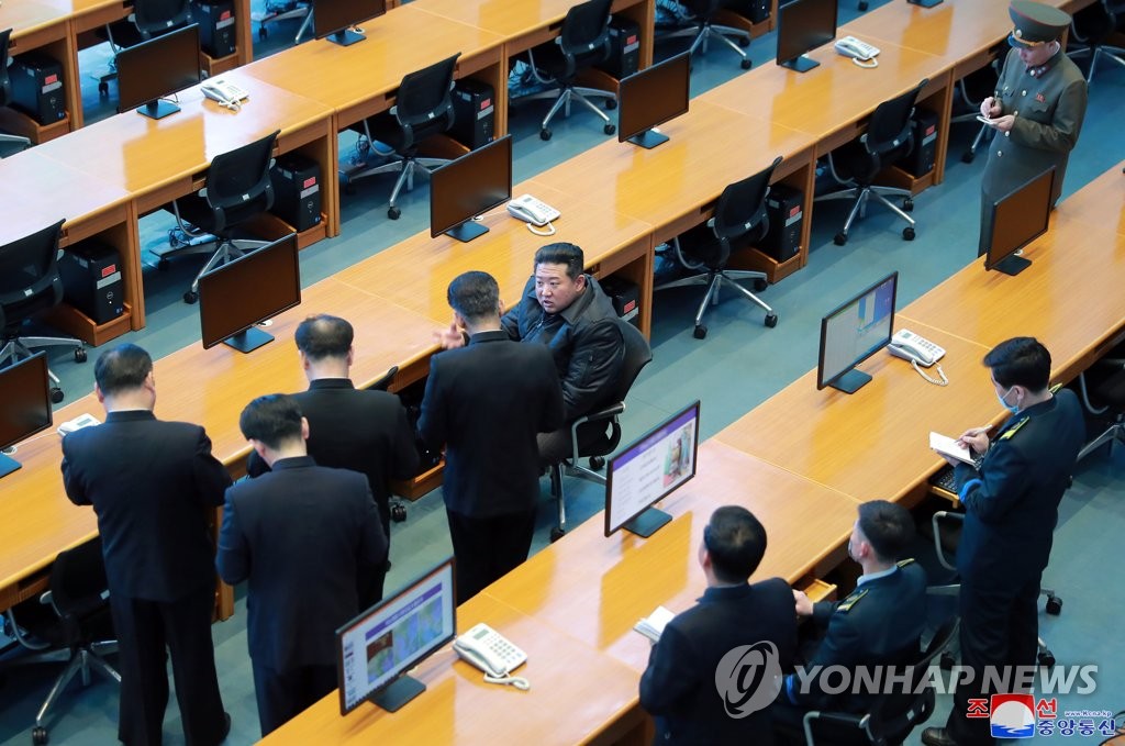 North Korea leader Kim Jong-un (C) speaks to officials during his visit to the National Aerospace Development Administration in this photo released by the North's official Korean Central News Agency on March 10, 2022. (For Use Only in the Republic of Korea. No Redistribution) (Yonhap) 