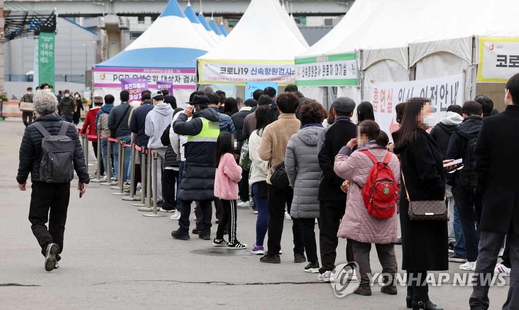 People line up to take COVID-19 tests at a temporary testing station in front of Seoul Station on March 18, 2022. (Yonhap)