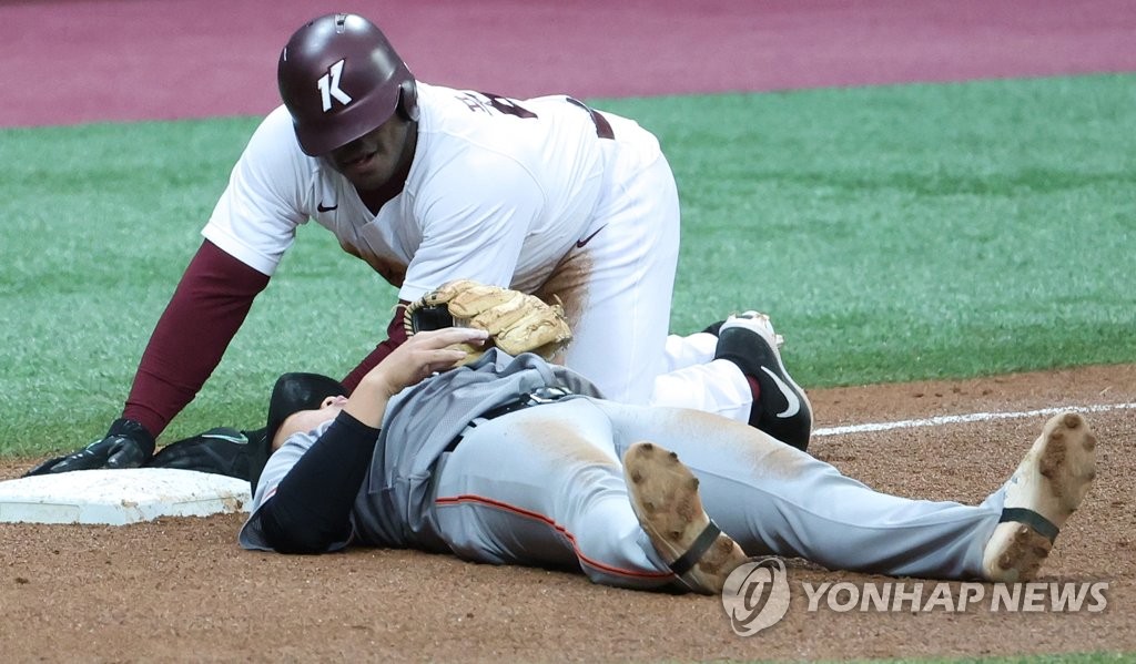 Yasiel Puig of the Kiwoom Heroes (R) looks at Hanwha Eagles third baseman Jeong Min-kyu after being tagged out at third base during the bottom of the fifth inning of a Korea Baseball Organization preseason game at Gocheok Sky Dome in Seoul on March 20, 2022. (Yonhap)