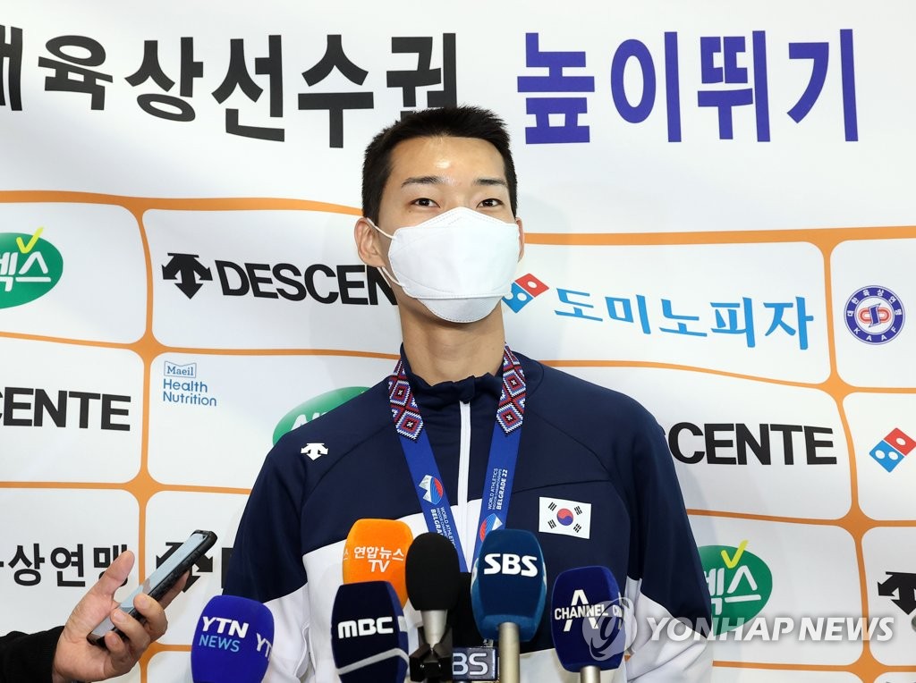 South Korean high jumper Woo Sang-hyeok speaks to reporters at Incheon International Airport on March 22, 2022, two days after winning the gold medal at the World Athletics Indoor Championships in Belgrade. (Yonhap)