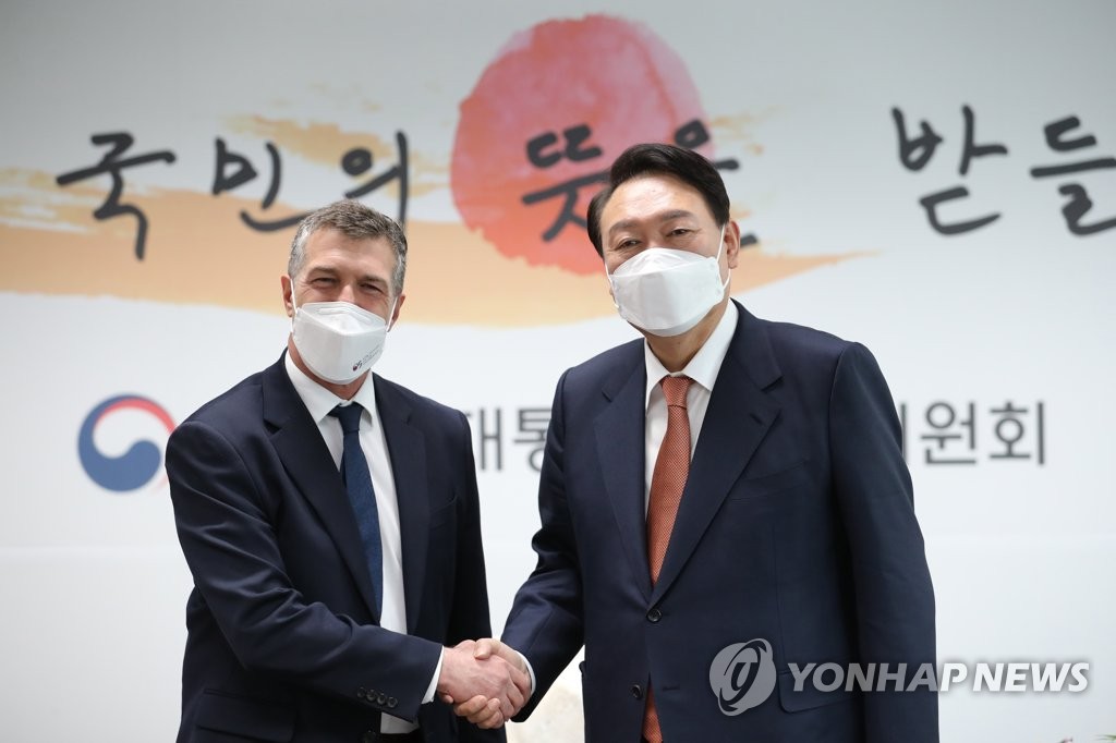 El presidente electo, Yoon Suk-yeol (dcha.), y el embajador de Israel ante Corea del Sur, Akiva Tor, se estrechan la mano, el 24 de marzo de 2022, en la oficina del primero, en Seúl. (Foto cortesía del comité de transición presidencial. Prohibida su reventa y archivo) 